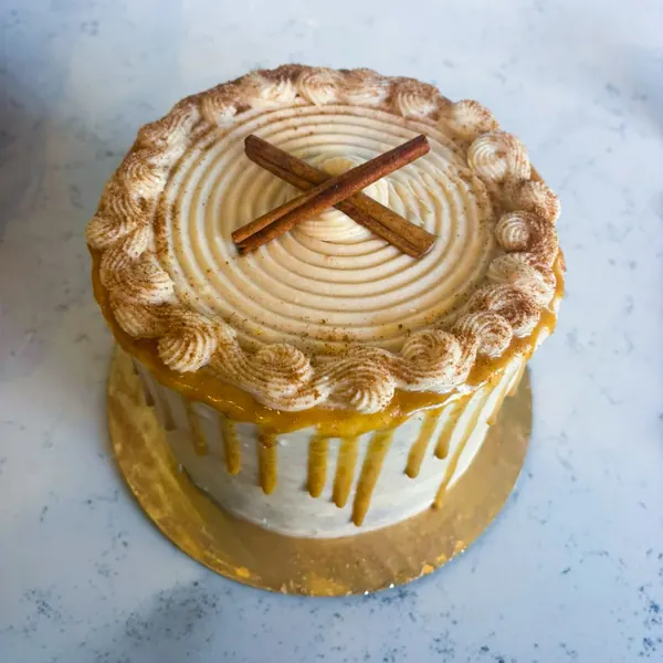 Cinnamon cake with caramel drip and crossed cinnamon sticks